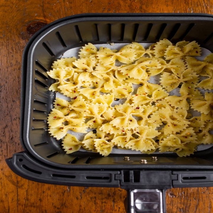 Pasta in the basket of an air fryer.